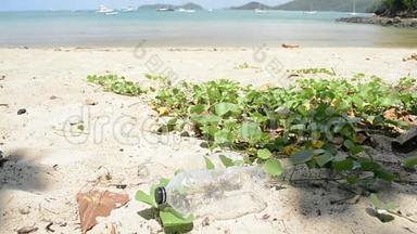 保洁员将沙滩上的垃圾收集成绿色塑料袋，塑料瓶则收集在沙滩上..